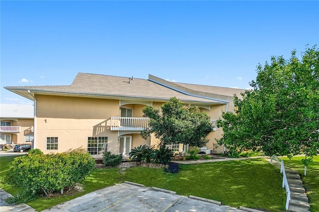 back of property featuring a yard and a balcony