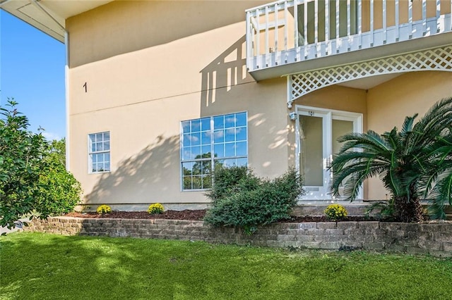 view of property exterior featuring a lawn and a balcony