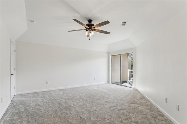 carpeted spare room featuring vaulted ceiling and ceiling fan