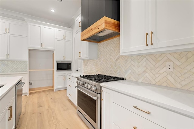 kitchen with white cabinets, backsplash, premium range hood, and appliances with stainless steel finishes