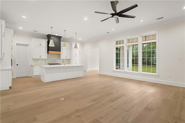 unfurnished living room featuring ceiling fan, light hardwood / wood-style flooring, and crown molding