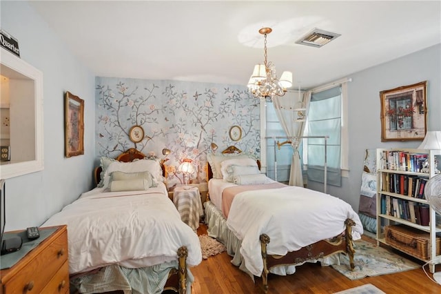 bedroom featuring light hardwood / wood-style flooring and a chandelier