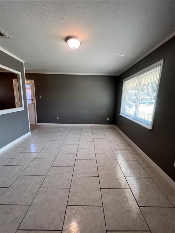 unfurnished room with a textured ceiling, light tile patterned floors, and crown molding