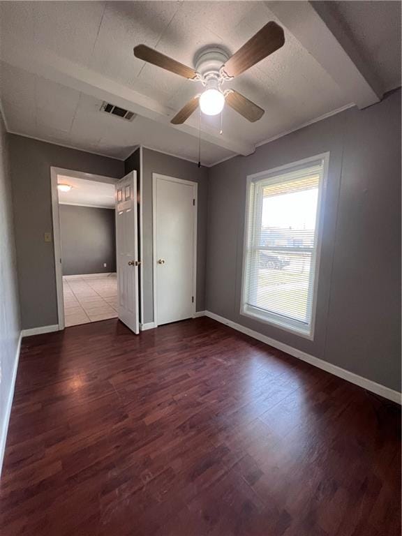 interior space featuring ceiling fan, beamed ceiling, and dark hardwood / wood-style flooring