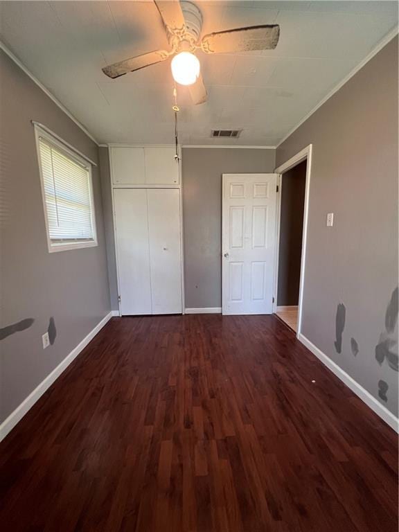 unfurnished bedroom featuring ornamental molding, dark hardwood / wood-style flooring, and ceiling fan