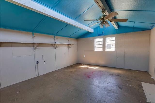 interior space featuring lofted ceiling with beams, concrete flooring, and ceiling fan