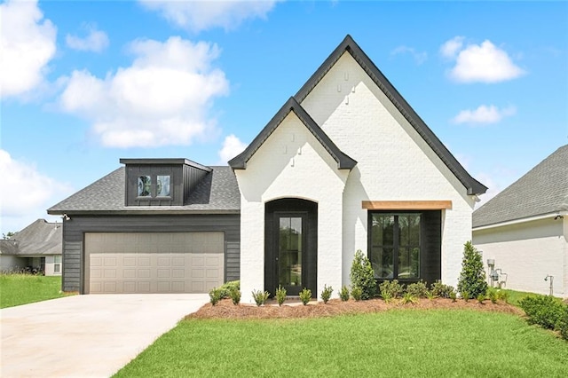 french provincial home with a front yard and a garage