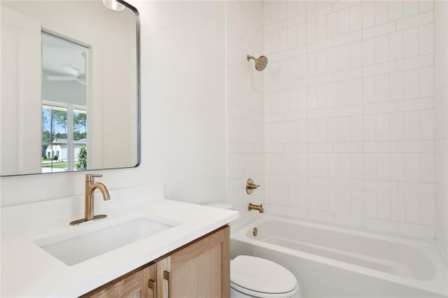 full bathroom with tiled shower / bath combo, vanity, toilet, and ceiling fan