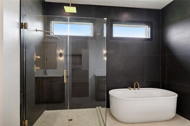 bathroom featuring independent shower and bath, vanity, and plenty of natural light