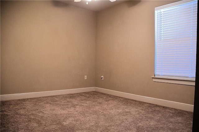 carpeted empty room featuring baseboards and ceiling fan
