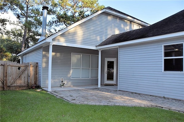 exterior space featuring a patio, a gate, fence, and a front yard