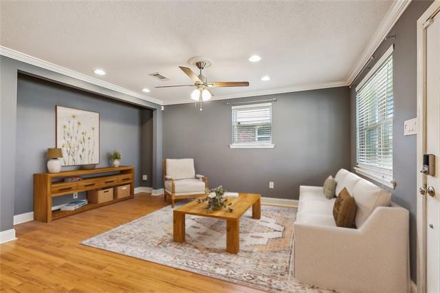 living room featuring crown molding, light hardwood / wood-style flooring, and ceiling fan