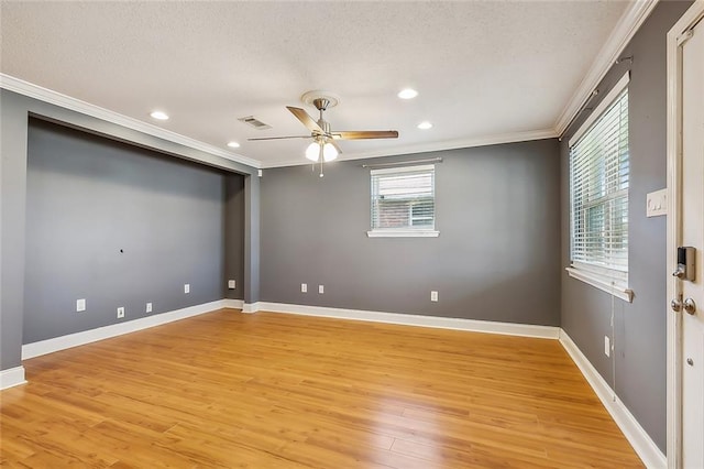 spare room featuring ceiling fan, a textured ceiling, light wood-type flooring, and crown molding