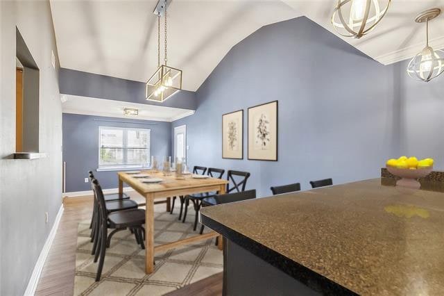 dining space with vaulted ceiling and hardwood / wood-style flooring