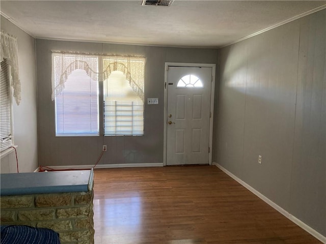 foyer entrance featuring wood-type flooring and crown molding