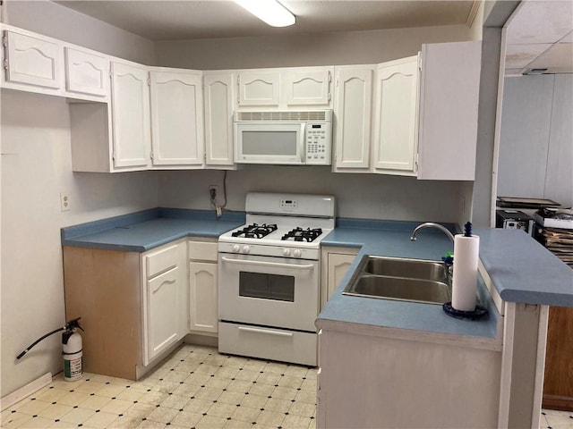 kitchen featuring sink, white appliances, and white cabinetry