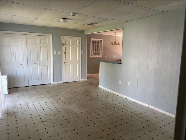 3008 Lake Villa Dr, Metairie, LA 70002 - unfurnished living room with tile patterned floors, visible vents, a notable chandelier, a paneled ceiling, and baseboards
