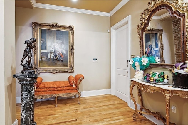 sitting room with wood-type flooring and crown molding