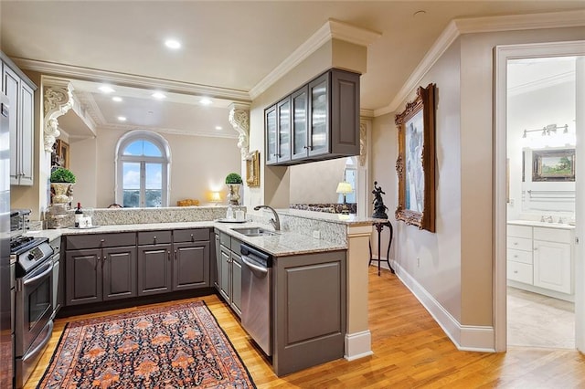 kitchen with ornamental molding, sink, kitchen peninsula, light hardwood / wood-style flooring, and appliances with stainless steel finishes