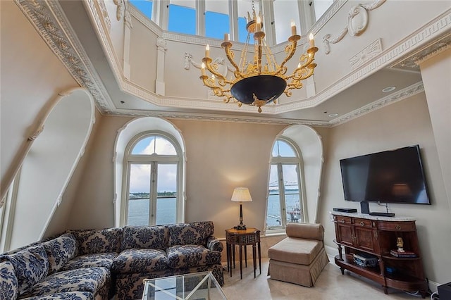 living room featuring ornamental molding, a towering ceiling, and a chandelier