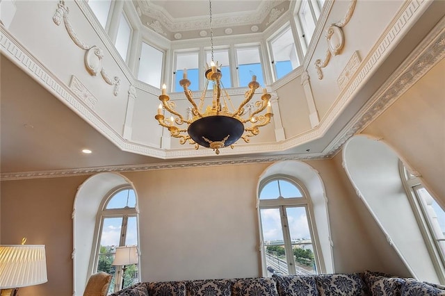 details with a notable chandelier, a raised ceiling, and crown molding