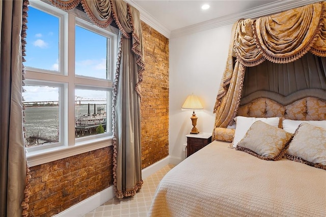 bedroom featuring ornamental molding, a water view, and brick wall