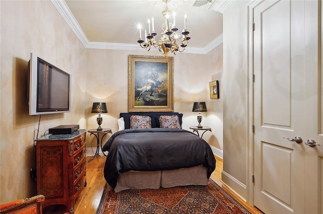 bedroom featuring ornamental molding, an inviting chandelier, and hardwood / wood-style flooring