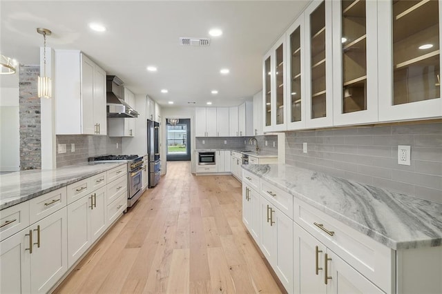 kitchen featuring white cabinets, light stone countertops, and stainless steel appliances