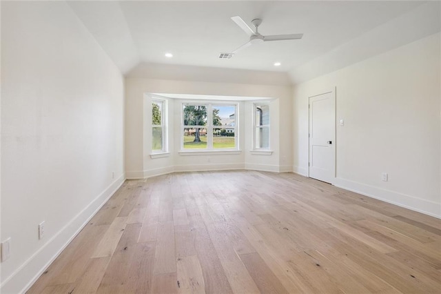 spare room with lofted ceiling, light wood-type flooring, and ceiling fan