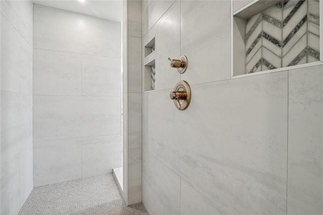 bathroom with a tile shower and tile walls