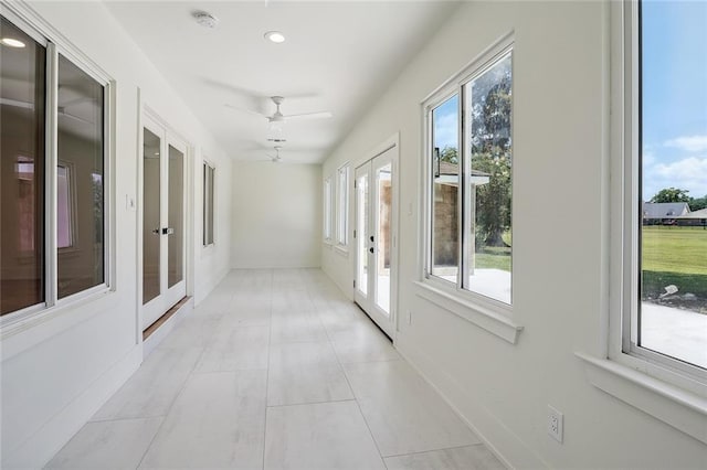 hallway featuring a wealth of natural light and light tile patterned floors