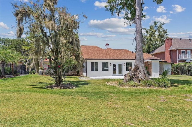 rear view of property with a yard