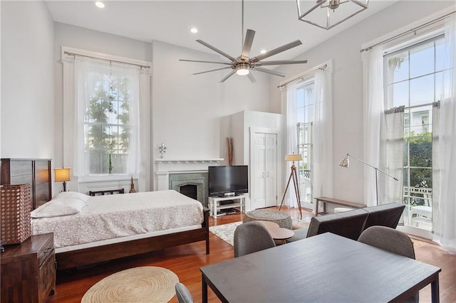 bedroom with wood-type flooring, multiple windows, and ceiling fan