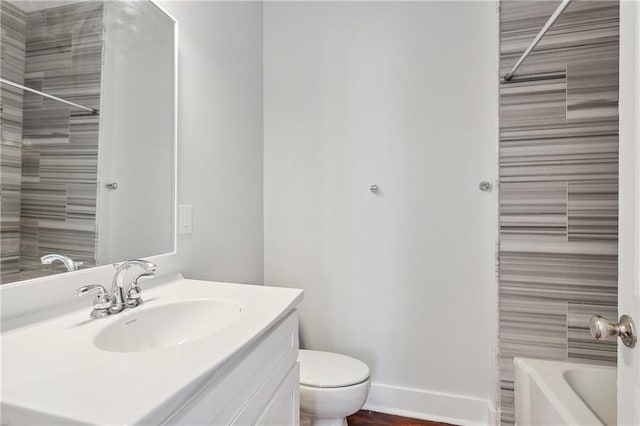 full bathroom featuring tiled shower / bath combo, vanity, and toilet