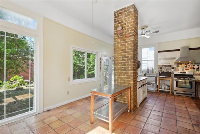 kitchen with white cabinets, gas range, ceiling fan, a healthy amount of sunlight, and extractor fan