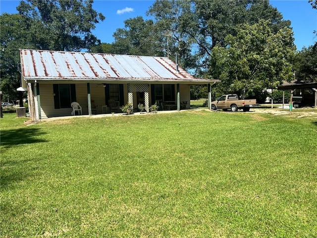 back of property featuring a carport, a yard, and central air condition unit