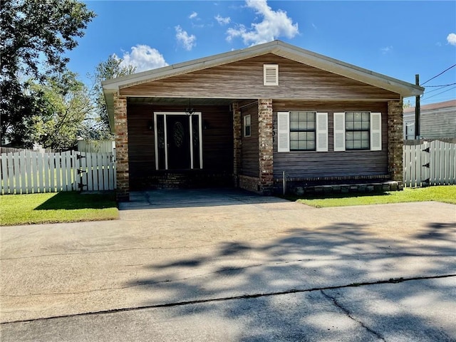 view of front of property featuring driveway, an attached carport, and fence