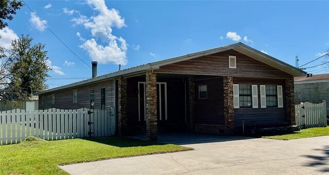 view of front of home with driveway, fence, a front yard, and a carport