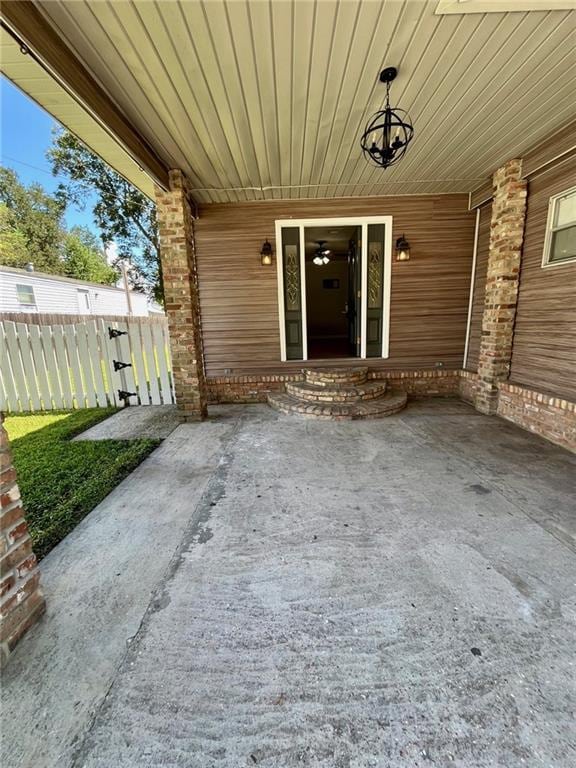 property entrance featuring fence and a porch