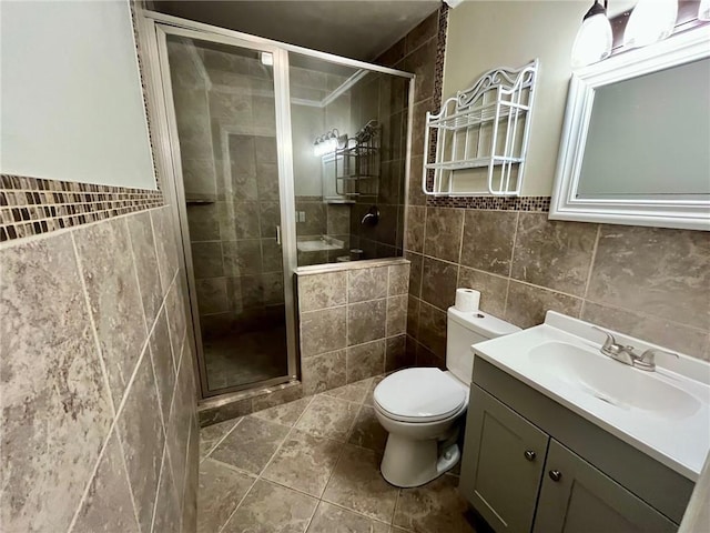 full bathroom featuring toilet, vanity, a stall shower, and tile walls