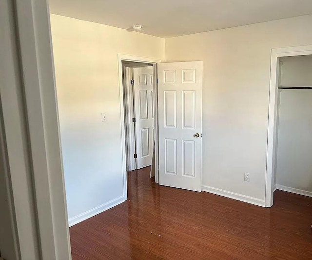 unfurnished bedroom with dark hardwood / wood-style flooring