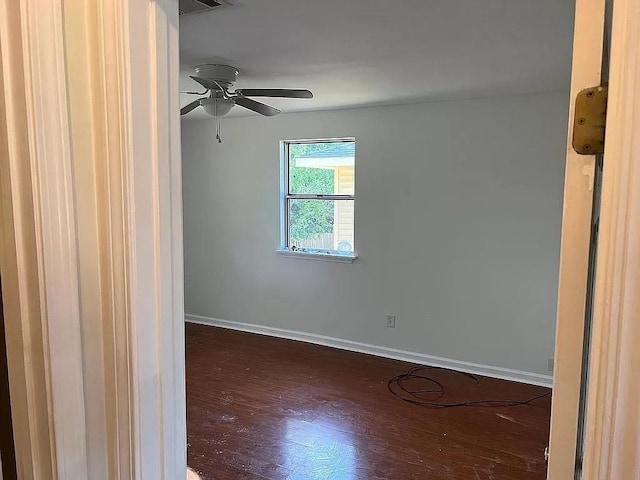 spare room featuring ceiling fan and dark wood-type flooring