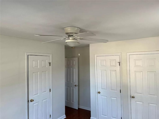 bedroom featuring ceiling fan and multiple closets