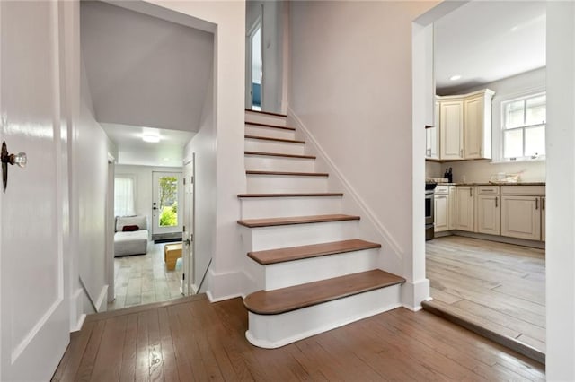 stairs featuring a wealth of natural light and hardwood / wood-style floors