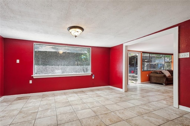 tiled empty room with a textured ceiling