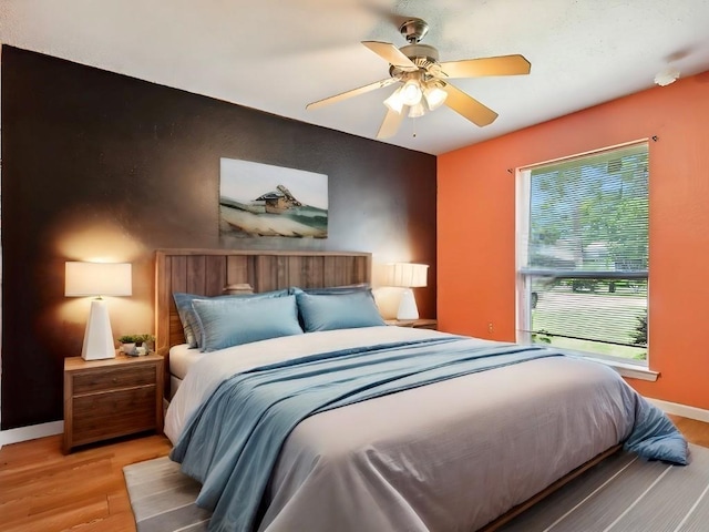 bedroom with ceiling fan and light hardwood / wood-style floors