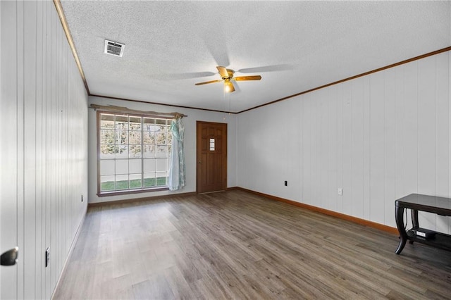 empty room featuring a textured ceiling, ornamental molding, hardwood / wood-style floors, and ceiling fan