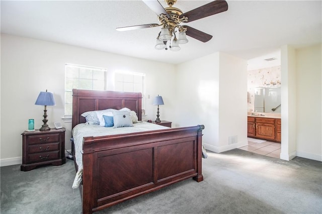 carpeted bedroom featuring ensuite bath and ceiling fan