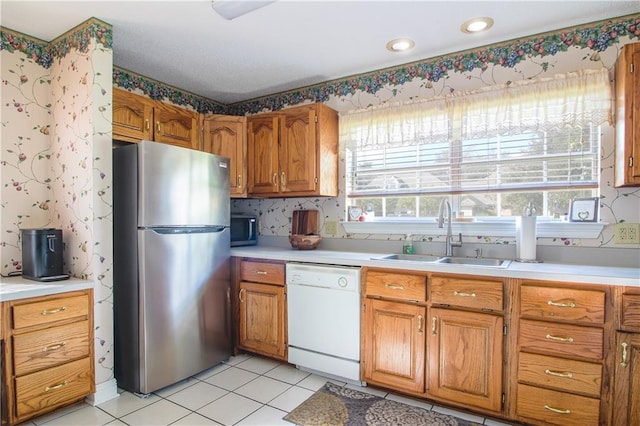 kitchen featuring sink, light tile patterned floors, stainless steel appliances, and a wealth of natural light