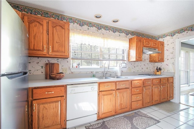 kitchen with appliances with stainless steel finishes, sink, and light tile patterned floors